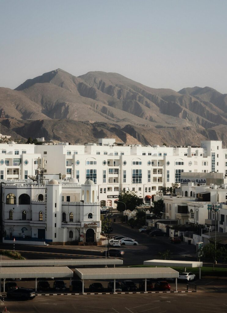 White buildings and arid mountains under a clear sky, showcasing city architecture.